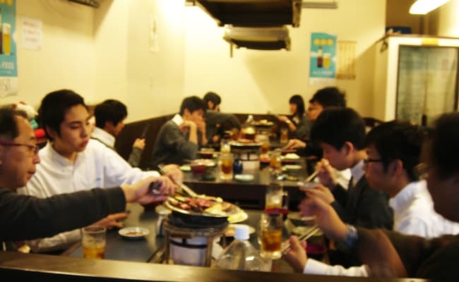 同窓会役員と生徒会のみんなで楽しく焼肉を食べている様子